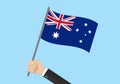 Australia waving flag. Hand holding Australian flag. National symbol with Southern Cross constellation. Vector illustration